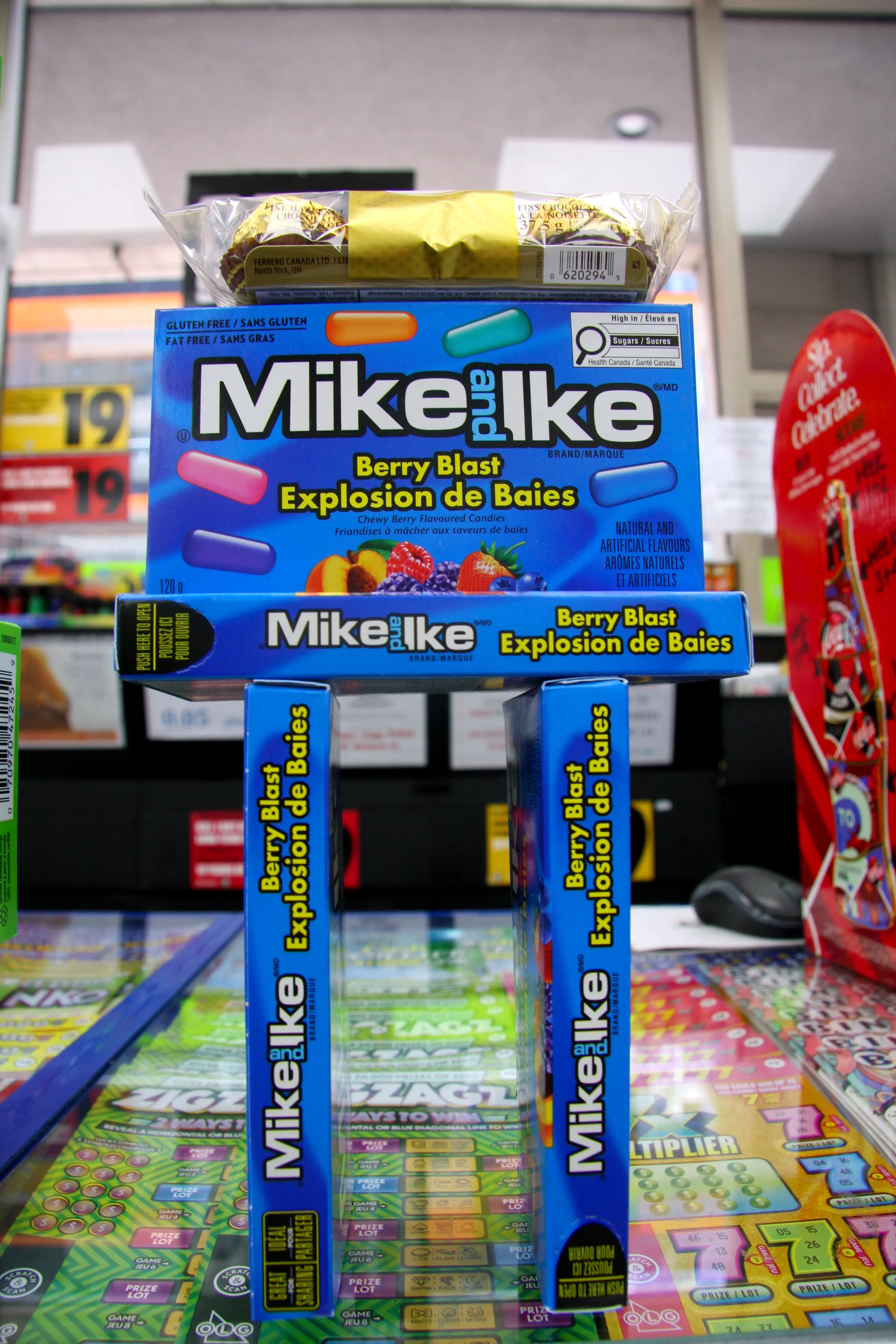 Candy and confectionery racked beside the counter, in front of the scratch ticket display.