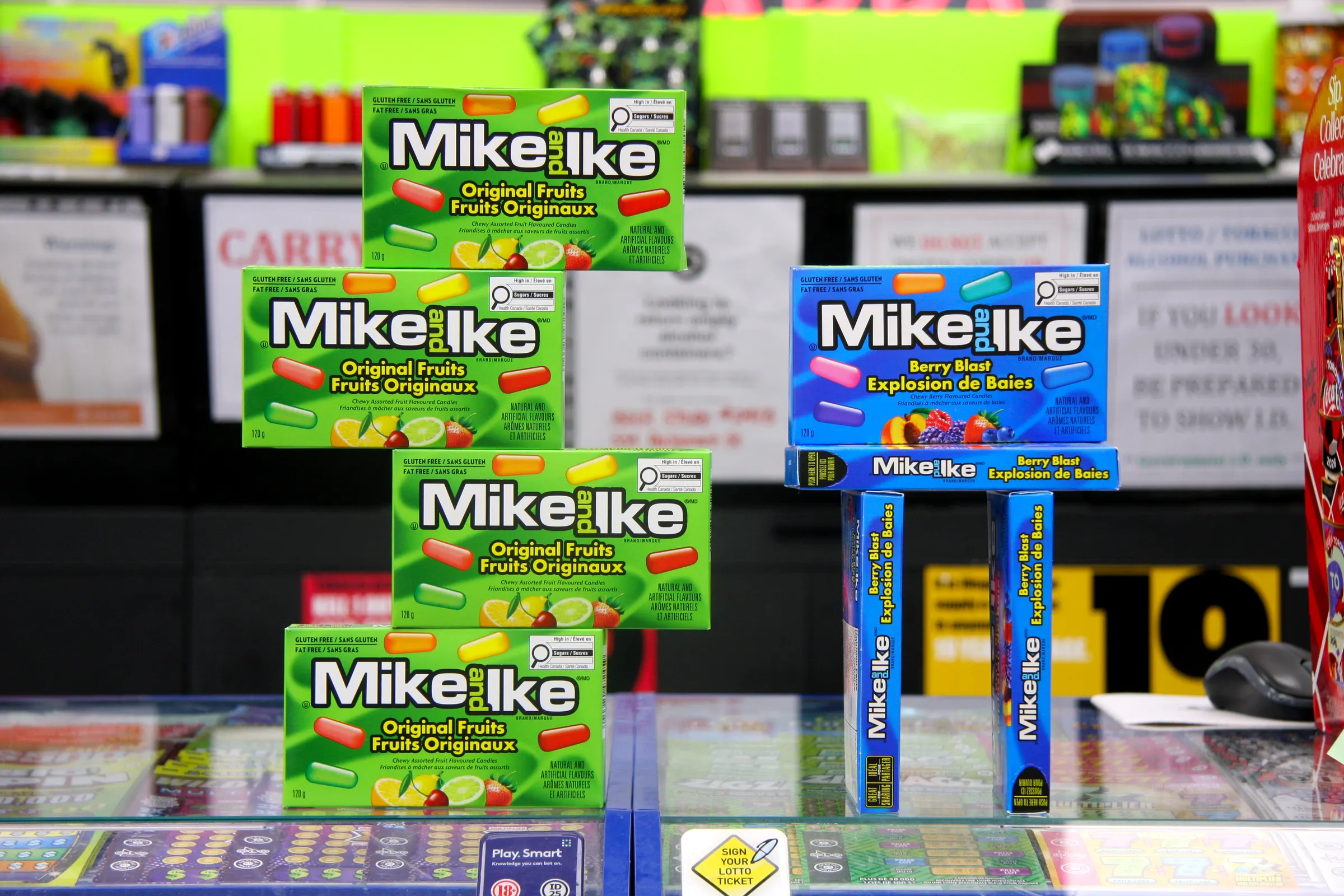 Boxed candy built into a display tower on the front counter, above the lottery ticket case.