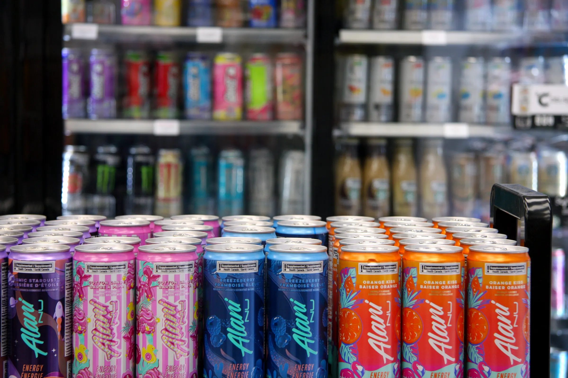 Energy drink display and cooler wall together, showing the depth of the cold beverage range.