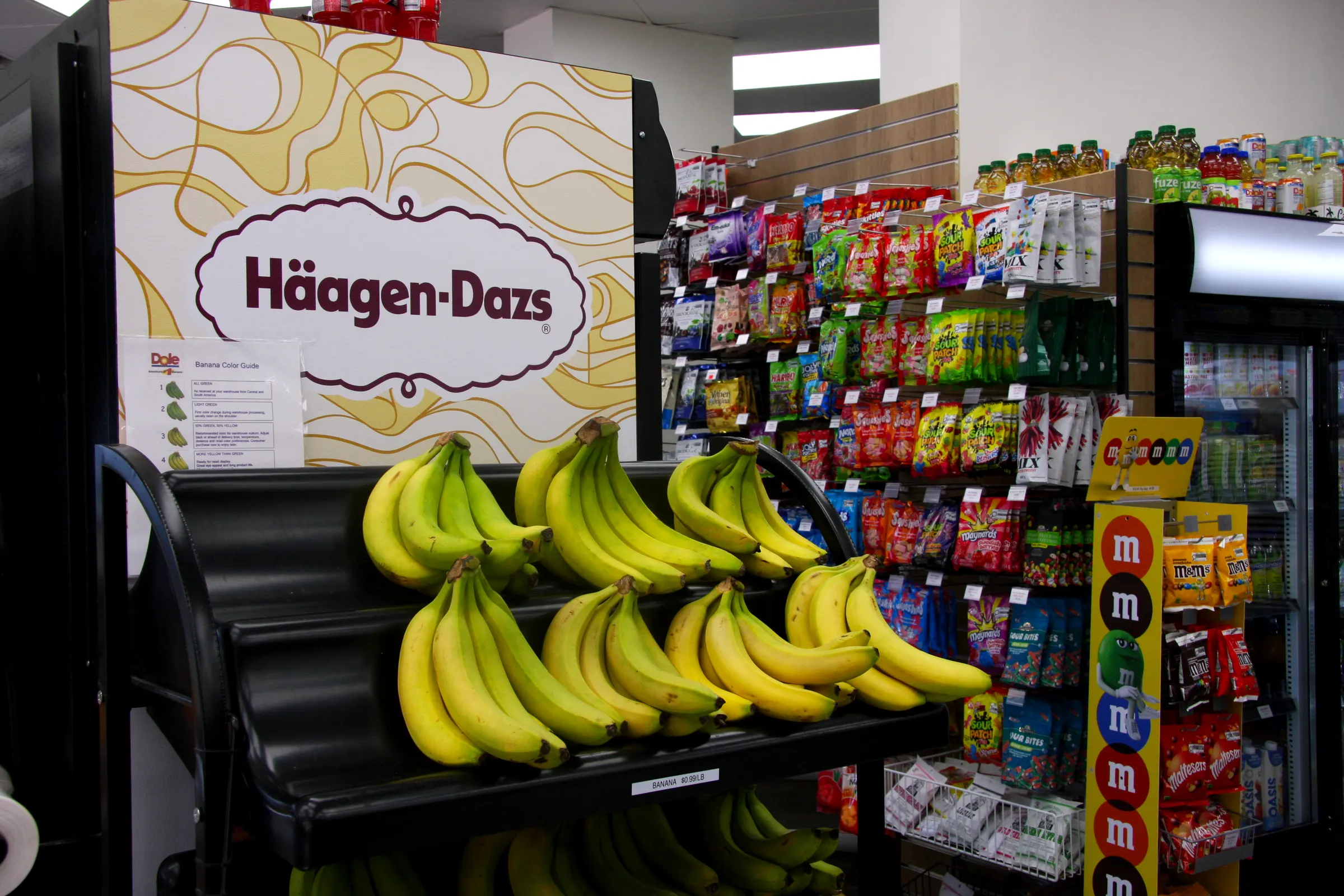 Bananas on the black end-cap display under the Häagen-Dazs header, candy and confectionery aisle behind.