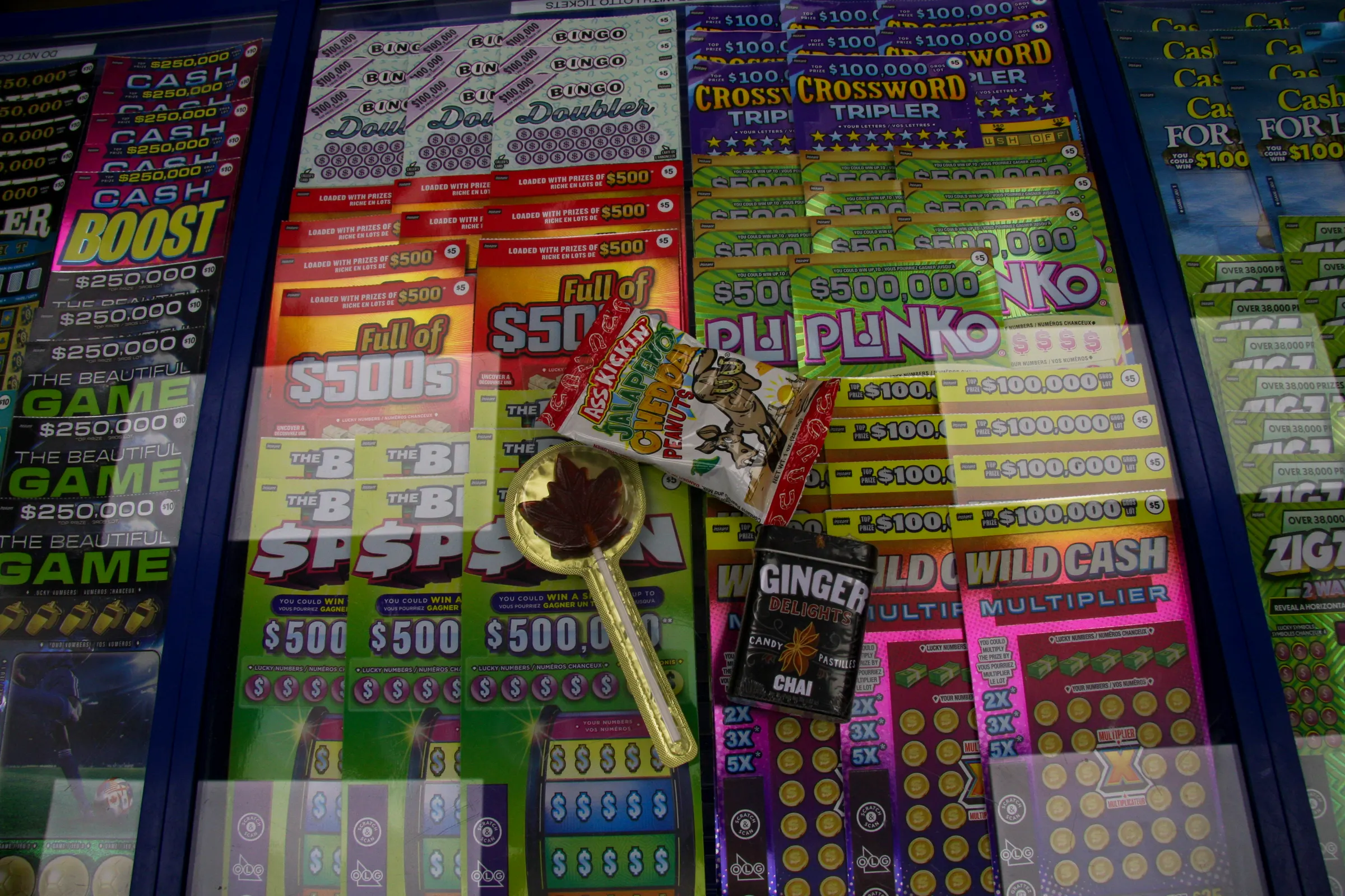 The lottery counter — scratch tickets laid out in rows under glass, a maple candy resting on top.